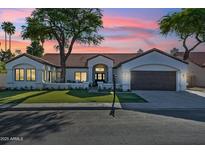 Charming single-story home showcasing a lush front yard and a beautiful sunset sky at 16428 N 59Th St, Scottsdale, AZ 85254