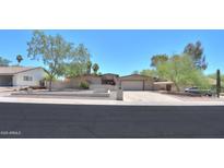 Charming single-story home featuring a large driveway, desert landscaping, and an American flag proudly displayed at 511 E Port Au Prince Ln, Phoenix, AZ 85022