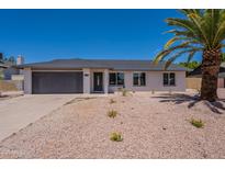 Charming single-story home featuring a two-car garage and desert-style landscaping for easy maintenance at 6944 E Gary Cir, Mesa, AZ 85207