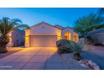 Charming single-story home with a well-manicured front yard and a spacious two-car garage at twilight at 8158 E Rita Dr, Scottsdale, AZ 85255