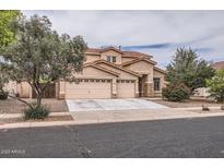 Charming two-story home features a three-car garage, desert landscaping, and a tile roof at 8766 W Hayward Ave, Glendale, AZ 85305