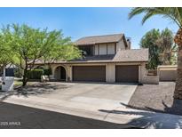 Two-story home with a three-car garage and a well-maintained front yard, offering classic curb appeal at 10759 N 101St St, Scottsdale, AZ 85260