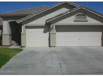 Home exterior featuring an attached two car garage with driveway and manicured lawn at 1412 E Oakland St, Gilbert, AZ 85295