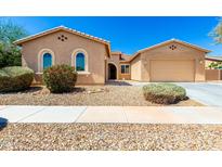 Inviting single-story home showcasing desert landscaping, a two-car garage, and a welcoming entrance at 16860 W Soft Wind Dr, Surprise, AZ 85387