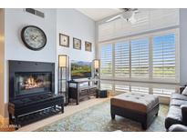 Bright living room features a cozy fireplace, plantation shutters, and a plush rug at 1701 E Colter St # 443, Phoenix, AZ 85016