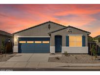 Charming single-story home featuring a blue garage door and shutters against a grey stucco exterior and landscaped front yard at 37153 W Prado St, Maricopa, AZ 85138