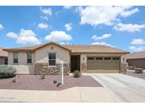 Charming single-story home with stone accents, desert landscaping, and a two-car garage at 6713 S 76Th Dr, Laveen, AZ 85339