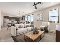 Bright living room featuring neutral colors, a ceiling fan, tile floors, and an open floor plan with a modern kitchen at 802 W Buist Ave, Phoenix, AZ 85041