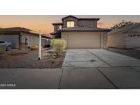 Two-story home featuring a large driveway and neutral-colored exterior with a red tile roof at 11215 W Heatherbrae Dr, Phoenix, AZ 85037