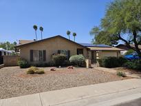 Charming home featuring a low-maintenance desert landscape, solar panels and a well-kept facade at 12016 N 45Th Ave, Glendale, AZ 85304