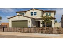 Charming two-story home featuring a tan exterior, terracotta roof, a garage and a well-manicured front yard at 12712 W Corona Ave, Avondale, AZ 85323