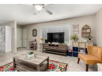 Inviting living room featuring a ceiling fan, a large window, stylish decor, and comfortable seating arrangements at 1402 E Guadalupe Rd # 114, Tempe, AZ 85283