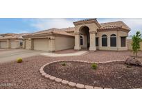 Charming home featuring a tile roof, arched entryway, and low maintenance desert landscaping at 3946 N 112Th Ave, Avondale, AZ 85392