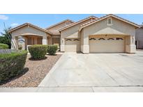 Charming single-story home with a neutral color scheme, well-maintained landscaping, and a spacious three-car garage at 4414 W Monte Way, Laveen, AZ 85339