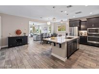 Open-concept kitchen featuring a spacious island, stainless steel appliances, and dark wood cabinetry at 549 E Balao Dr, Phoenix, AZ 85085