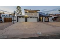 Two-story home featuring two-car garage, balcony, solar panels, and unique dark trim detail at 6216 W Poinsettia Dr, Glendale, AZ 85304