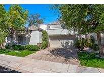 Inviting home exterior with manicured lawn and a two-car garage shaded by mature trees at 7272 E Gainey Ranch Rd # 23, Scottsdale, AZ 85258