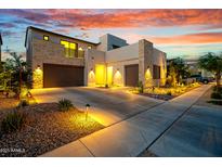 Modern home with stone accents, desert landscaping, and a two-car garage at sunset at 826 E Buist Ave, Phoenix, AZ 85042