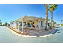 Charming manufactured home featuring a covered porch and meticulously landscaped front yard in a well-maintained community at 111 S Greenfield Rd # 547, Mesa, AZ 85206