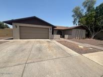 Charming single-story home with a two-car garage, complemented by a well-maintained front yard and covered entryway at 1841 S Spruce --, Mesa, AZ 85210