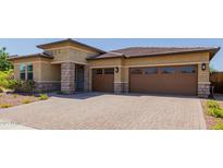 Inviting exterior showcasing a well-manicured front yard, stone accents, and a two-car garage at 20603 W Alsap Rd, Buckeye, AZ 85396