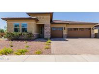 Charming single-story home showcasing a well-manicured lawn and inviting three-car garage at 20603 W Alsap Rd, Buckeye, AZ 85396