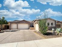 Beautiful single-story home with stone accents, desert landscaping, and a three-car garage at 2308 E Dry Wood Rd, Phoenix, AZ 85024