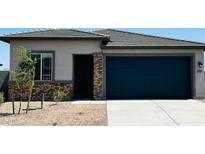 Charming single-story home featuring a blue garage door, stone accents, and a well-maintained front yard at 25133 W Wayland Dr, Buckeye, AZ 85326