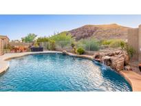 Backyard pool featuring dining set, waterfall feature, and beautiful mountain views at 26330 N 56Th Dr, Phoenix, AZ 85083