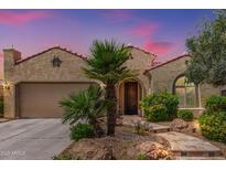 Charming home featuring a stucco exterior, clay tile roof, desert landscaping, and mature palm trees at 27088 W Sequoia Dr, Buckeye, AZ 85396