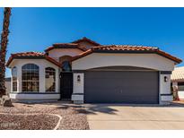 Charming single-story home with a terracotta roof and a well-maintained two-car garage at 5125 W Wickiup Ln, Glendale, AZ 85308