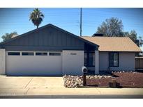 Charming single-story home featuring a two-car garage, manicured desert landscaping, and crisp painted brick at 5529 W Zoe Ella Way, Glendale, AZ 85306