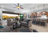 Spacious living room with modern furnishings that seamlessly connect to the gourmet kitchen and outdoor spaces at 8633 E Kael Cir, Mesa, AZ 85207