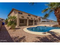 Backyard oasis with sparkling pool, lush palms, and covered patio, ideal for relaxation and entertaining at 11511 E Renata Ave, Mesa, AZ 85212