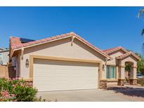 Charming single-story home with a two-car garage, desert landscaping, and a red tile roof at 16526 W Desert Ln, Surprise, AZ 85388