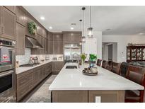 Gourmet kitchen features an extended island counter with seating and flowers at 3331 N Acacia Way, Buckeye, AZ 85396