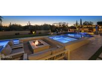 Inviting backyard oasis featuring a pool, spa, fire pit and lounge area for relaxing and entertaining at 35556 N 87Th Pl, Scottsdale, AZ 85266