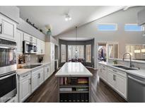 Bright kitchen with a large island, white cabinetry, modern appliances, and gray backsplash at 4569 E Lariat Ln, Phoenix, AZ 85050