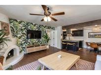 Inviting living room featuring a charming fireplace, hardwood floors, and open layout to the modern kitchen at 7557 N Dreamy Draw Dr # 139, Phoenix, AZ 85020