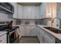 Updated kitchen features white cabinets, stainless steel appliances, and subway tile backsplash at 9600 N 96Th St # 171, Scottsdale, AZ 85258