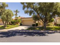 Charming single-story home featuring a well-manicured lawn and a two-car garage at 10429 N 101St St, Scottsdale, AZ 85258