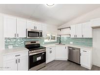Bright kitchen features white cabinetry, stainless steel appliances, and a stylish subway tile backsplash at 11000 N 91St Ave # 20, Peoria, AZ 85345