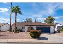 Charming single-story home featuring mature palm trees, a two-car garage, and a well-maintained yard at 1800 W Shawnee Dr, Chandler, AZ 85224