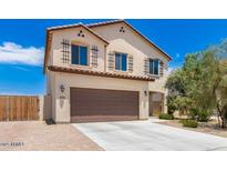 Charming two-story home featuring a front-facing two car garage and desert landscaping at 18514 W Williams Rd, Surprise, AZ 85387