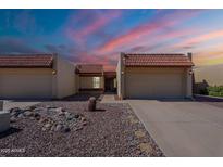 Charming home featuring desert landscaping, a tile roof, and a two-car garage, all under a vivid sky at 2527 E Villa Theresa Dr, Phoenix, AZ 85032