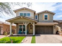 Charming two-story home featuring a welcoming front porch, two-car garage, and landscaped yard at 2562 N Springfield St, Buckeye, AZ 85396