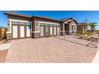 Charming single-story home boasting a stylish facade with stone accents and a paved driveway under a clear blue sky at 27647 N 176Th Dr, Surprise, AZ 85387
