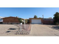Charming single story home with a brick facade, low maintenance desert landscaping, and a driveway leading to a single garage at 2933 W Del Mar Ln, Phoenix, AZ 85053