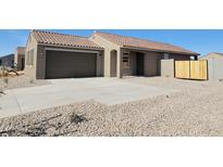 Single-story home with a tile roof, desert landscaping, and a two-car garage at 329 S San Christo Ln, Casa Grande, AZ 85194