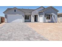 Charming single-story home with a three-car garage and a paver driveway at 4822 W Owl Head Pl, San Tan Valley, AZ 85144